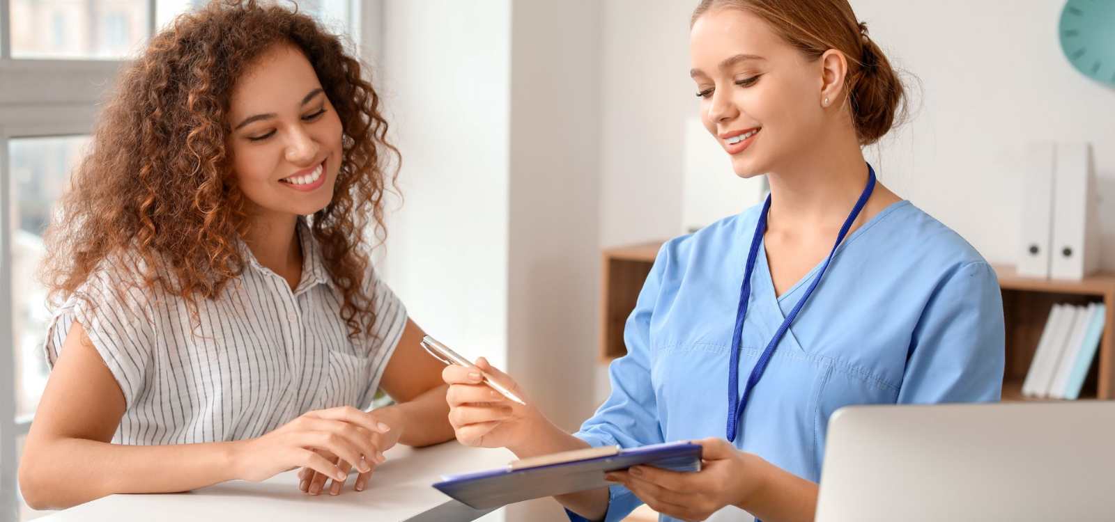 two women looking at clipboard